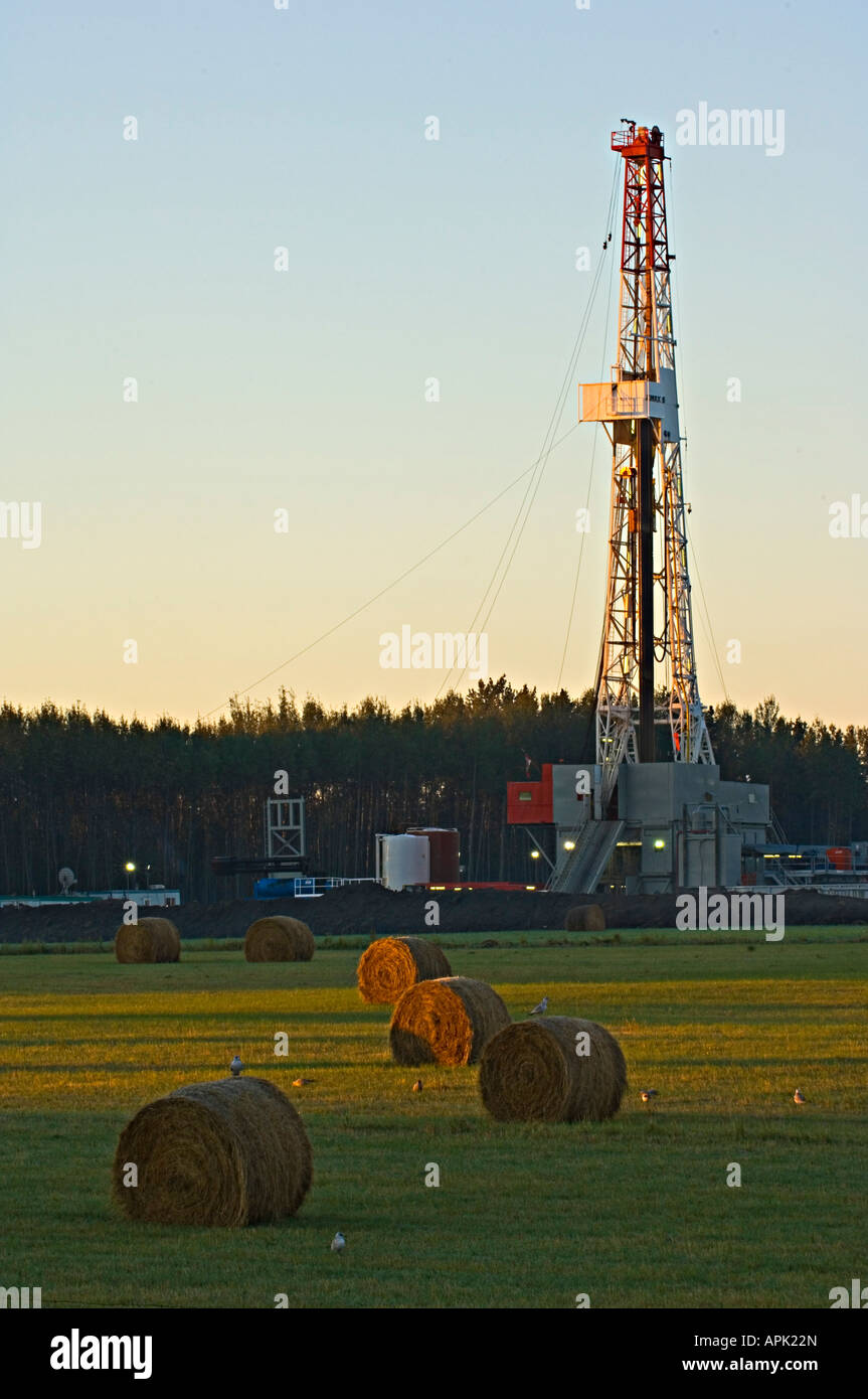 A drill rig exploring for underground minerals in a farm field. Stock Photo