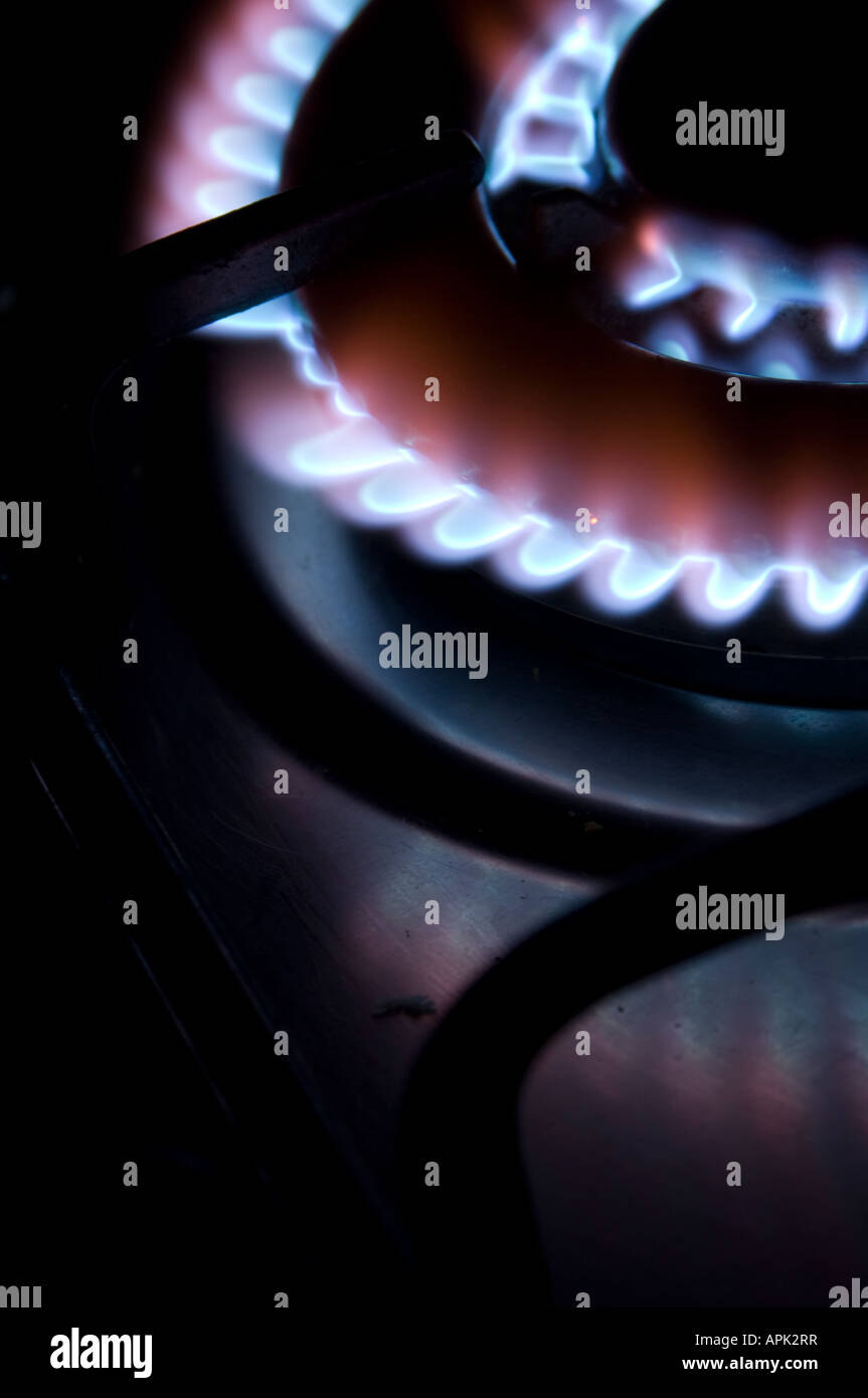 gas hob cooker blue flames heating elements glowing ablaze in the dark
