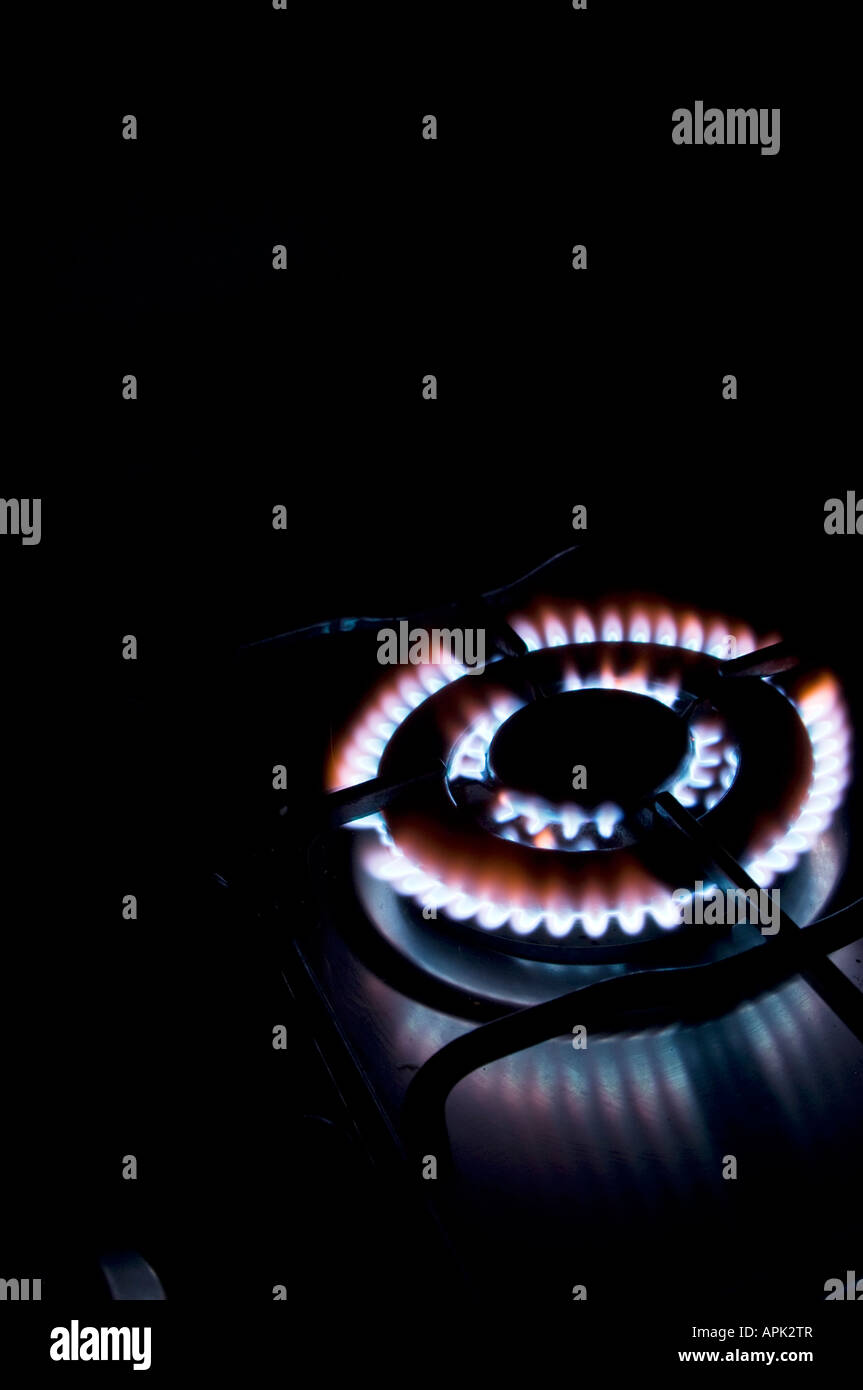 gas hob cooker blue flames heating elements glowing ablaze in the dark