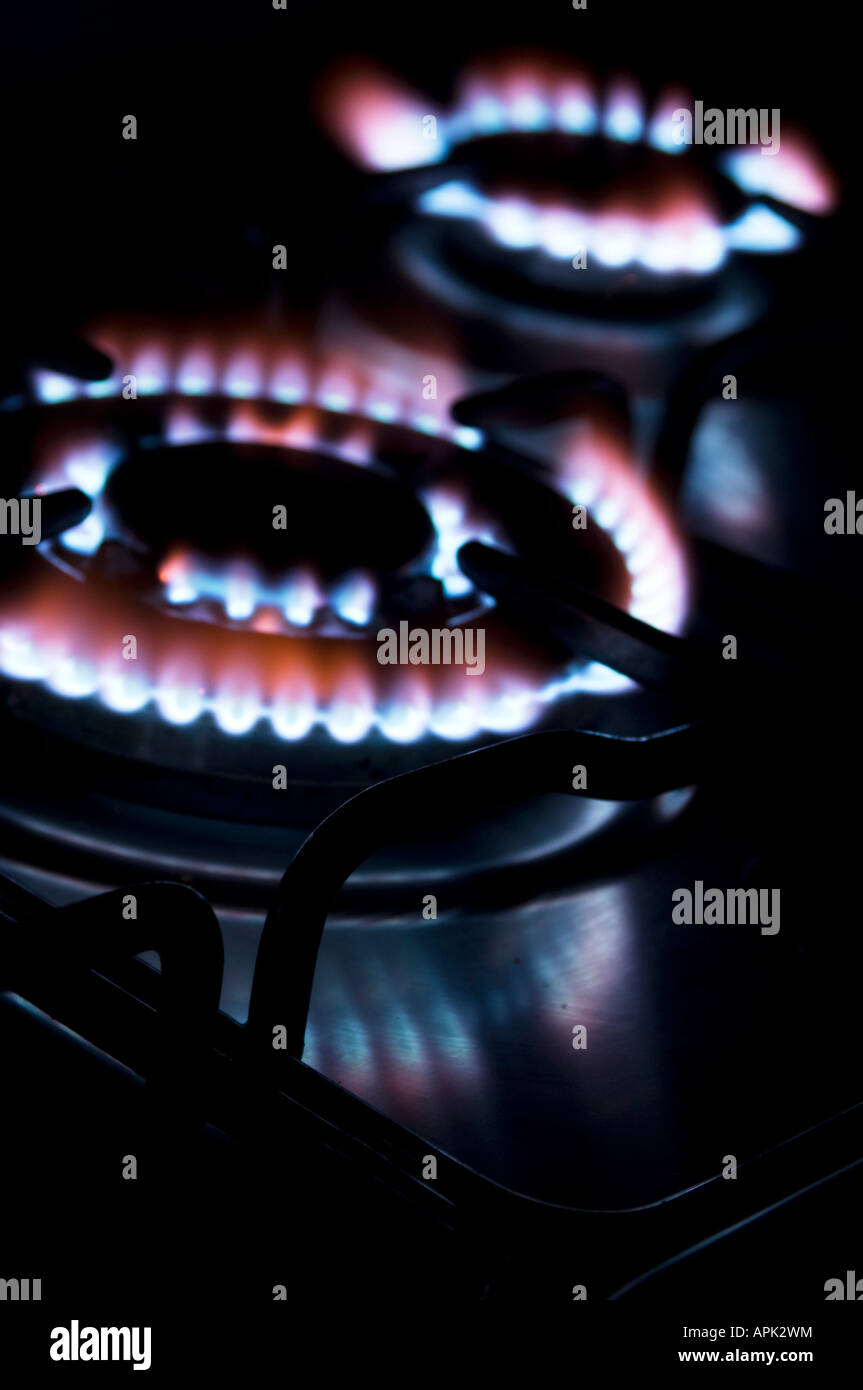 gas hob cooker blue flames heating elements glowing ablaze in the dark