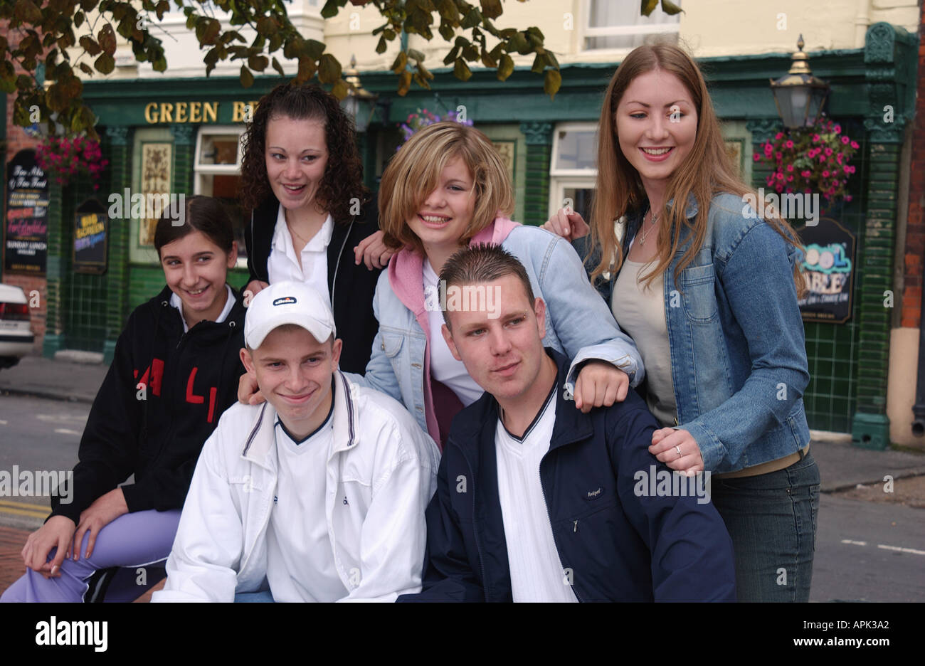 group of teenage boys and girls sitting outside Stock Photo - Alamy