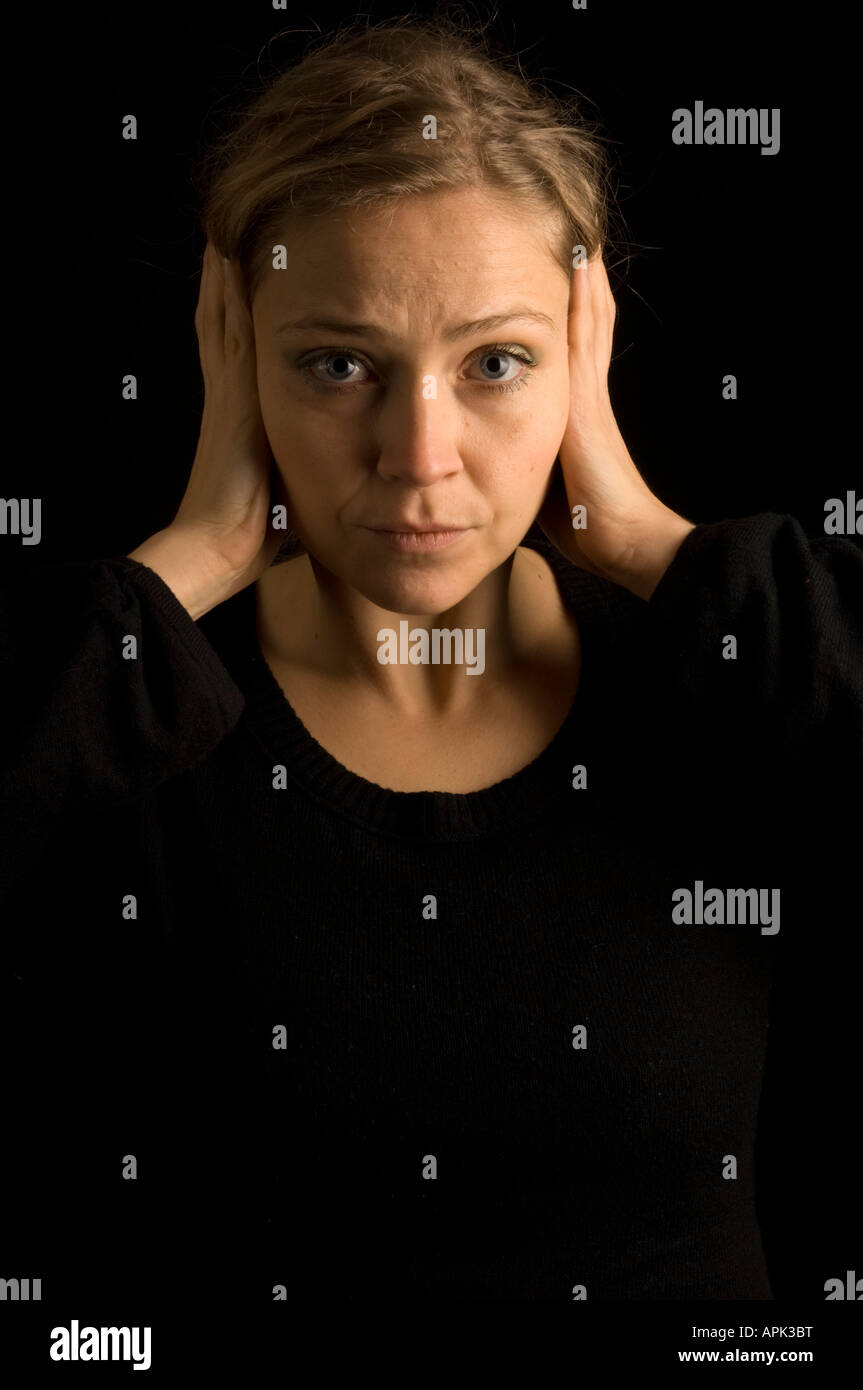 woman with her hands over her ears to prevent herself from hearing