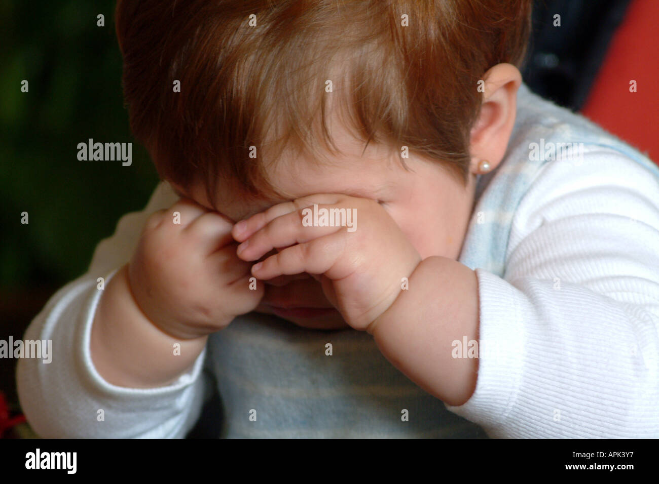 Sleepy baby girl rubbing her eyes Stock Photo Alamy