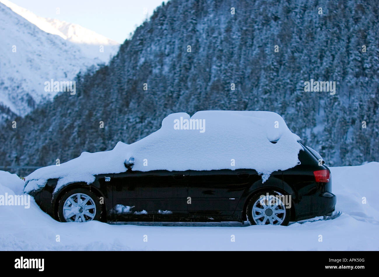 Snowed under estate car in the main carpark outside the car free ski resort of Saas Fee in the Wallis mountain range in Switzerl Stock Photo