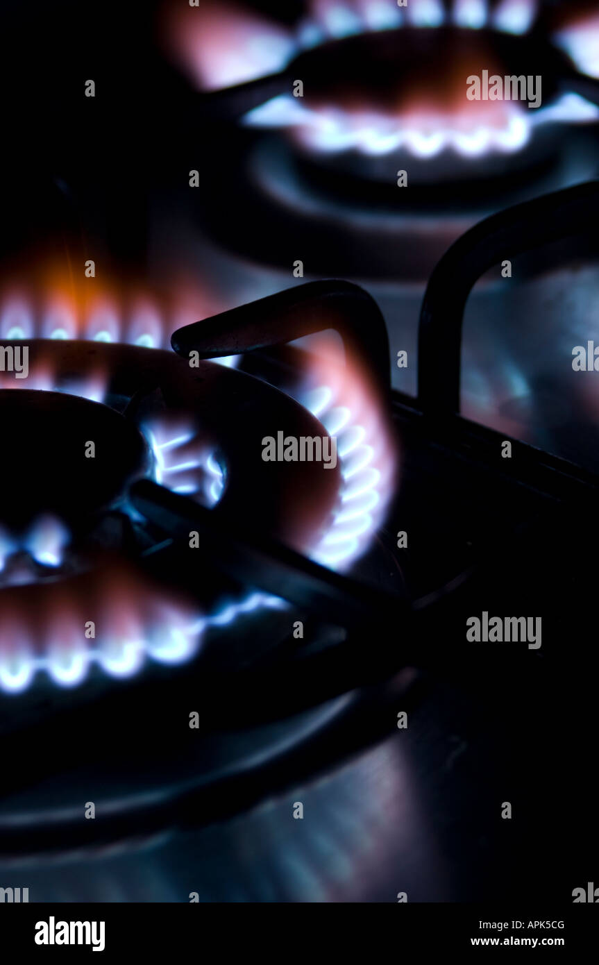 Gas cooker flames on a cooker stove hob in the dark UK Stock Photo