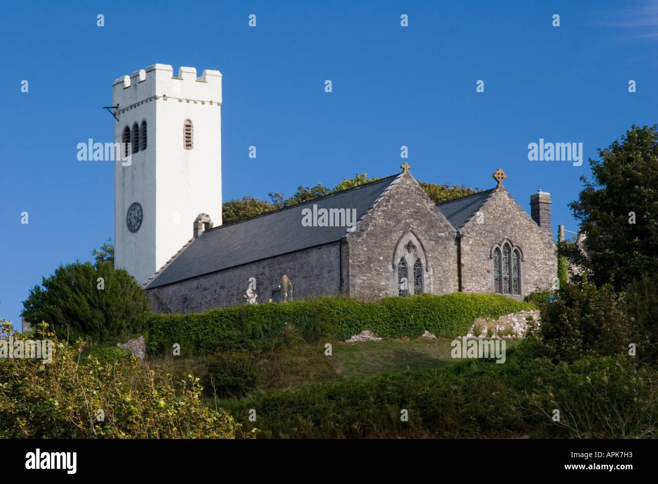The church with limewash painted white tower at Manorbier in Pembrokeshire Wales Stock Photo