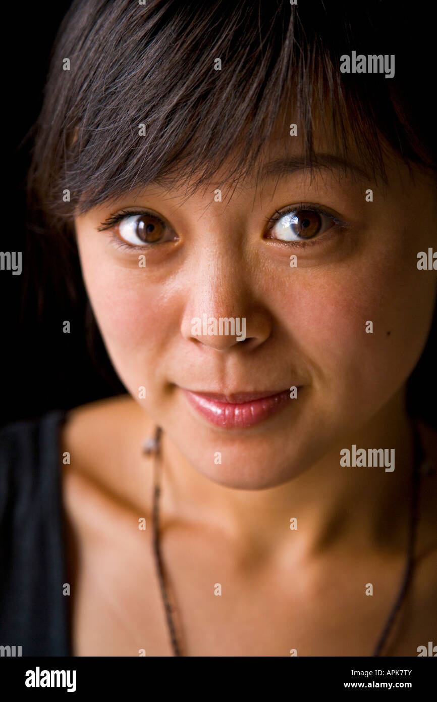 Close-up portrait beautiful asian oriental Chinese young woman big brown eyes smiling looking at camera Beijing China JMH2984 Stock Photo