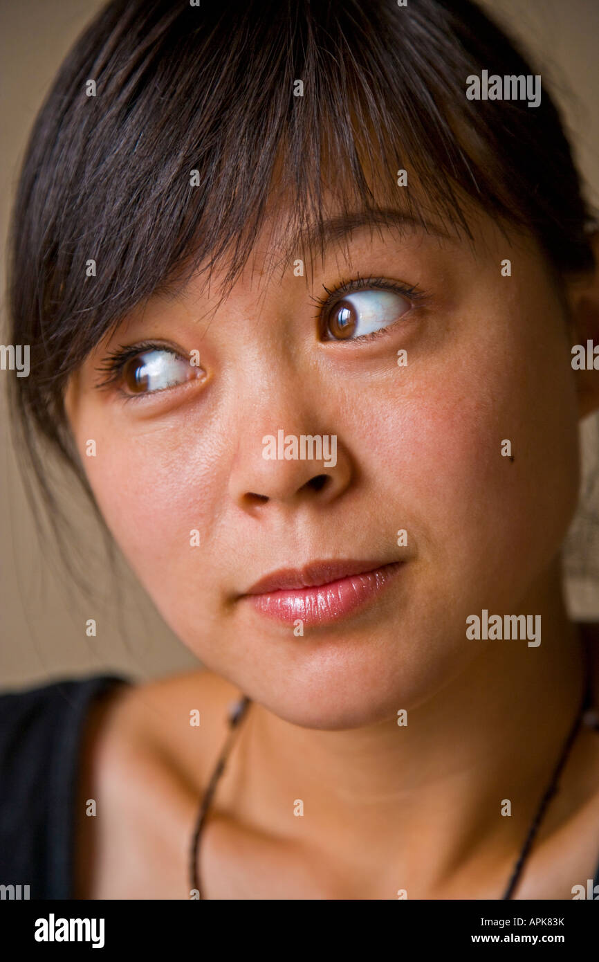 Close-up portrait beautiful asian oriental Chinese young woman big brown eyes looking away from camera Beijing China JMH2991 Stock Photo