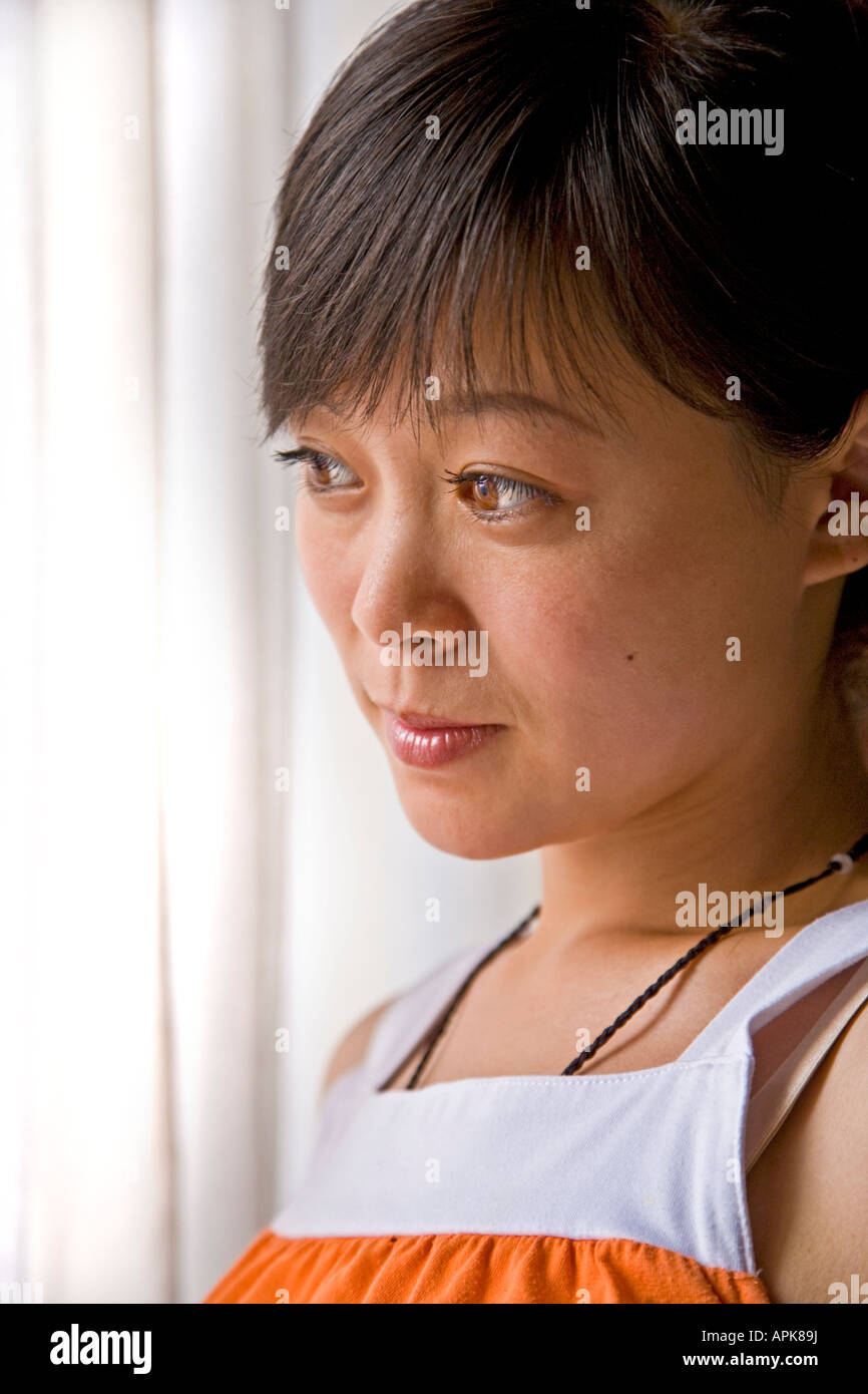 Close-up portrait beautiful asian oriental Chinese young woman big brown eyes semi profile white curtains Beijing China JMH2997 Stock Photo