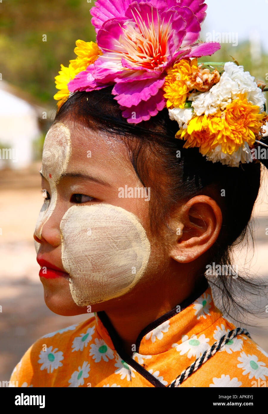 side portrait of a young Burmese Girl with traditional face paint made