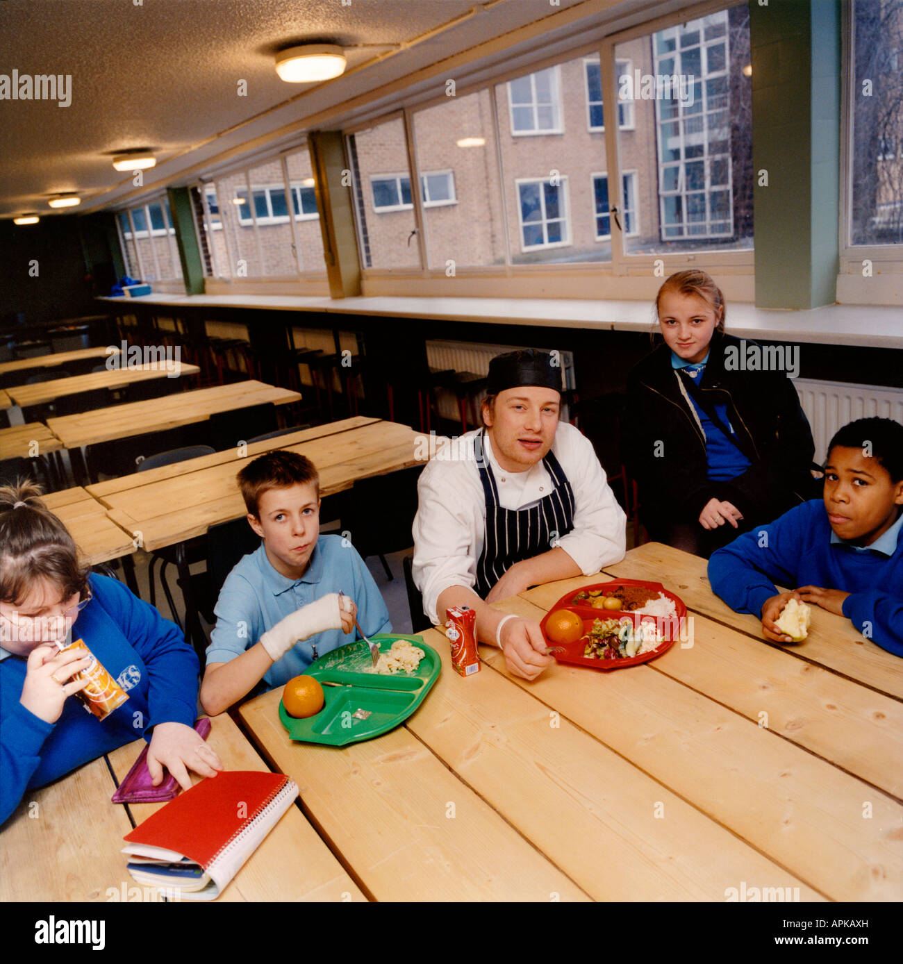 Chef Jamie Oliver with school children after serving them school dinner as part of his campaign to make them healthier. Stock Photo