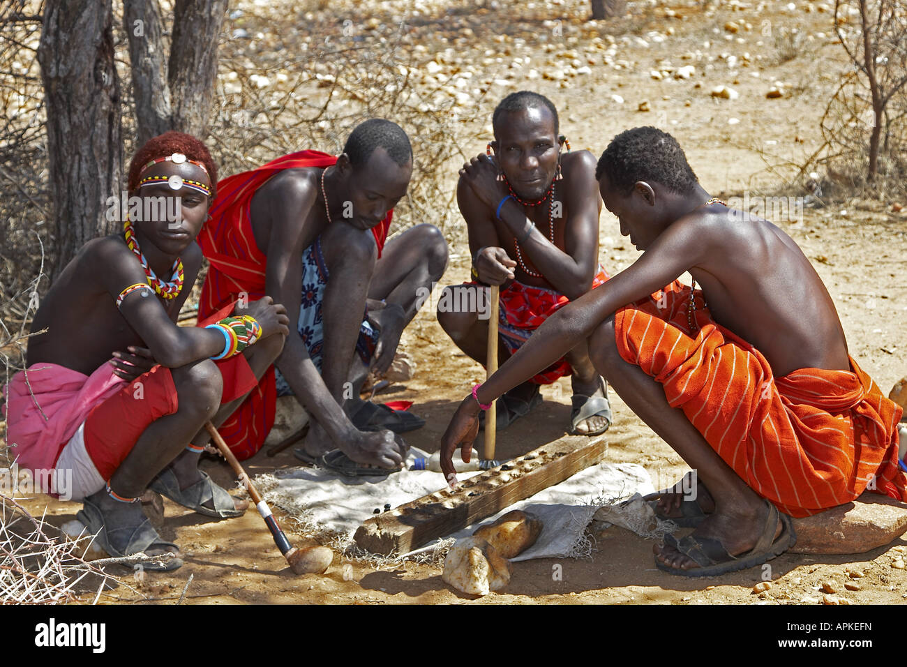 four Samburu men playing a parlour game, Kenya, Samburu Gebiet, Isiolo Stock Photo