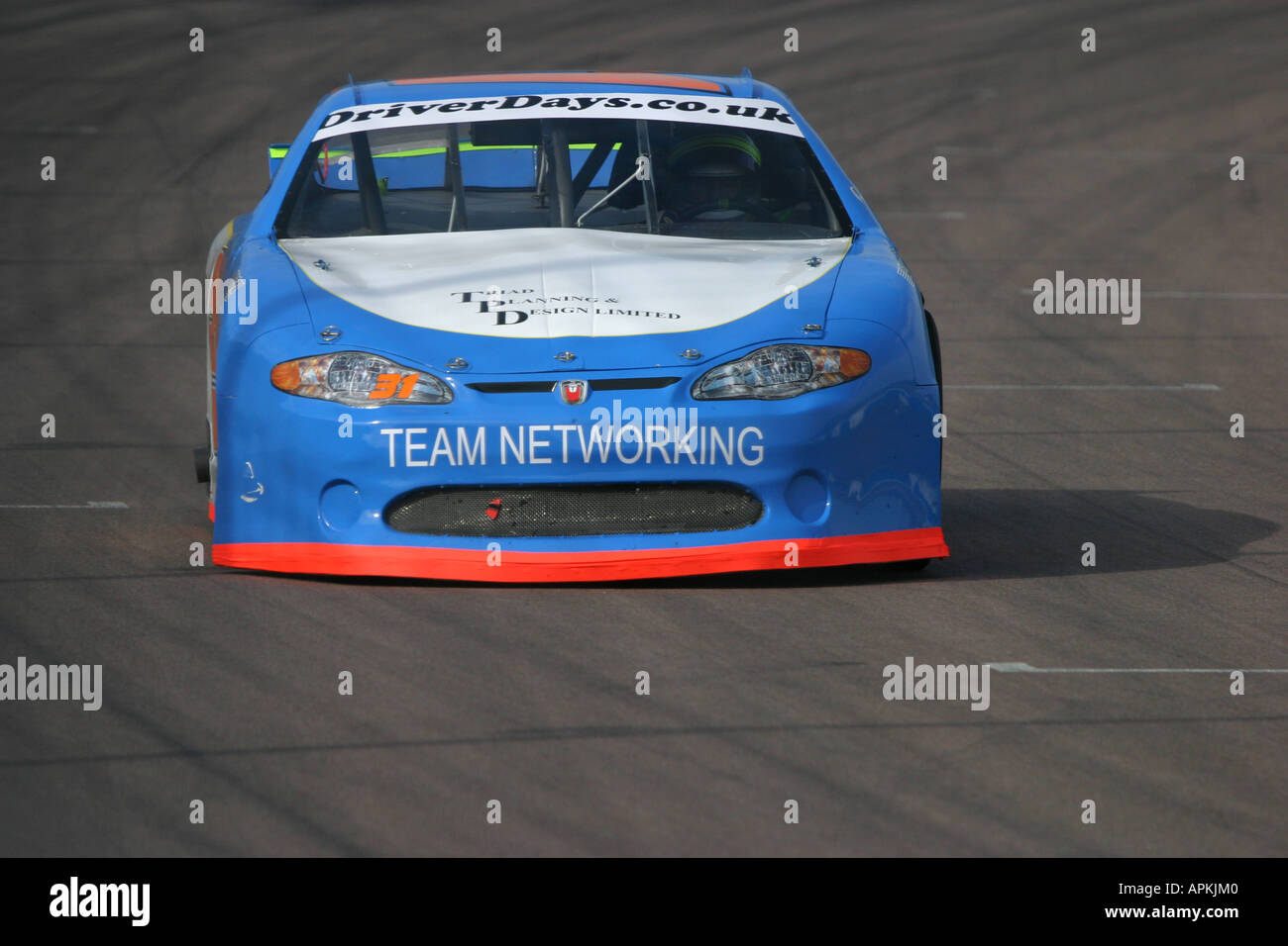 V8 Nascar type stock cars racing on a banked oval circuit Stock Photo