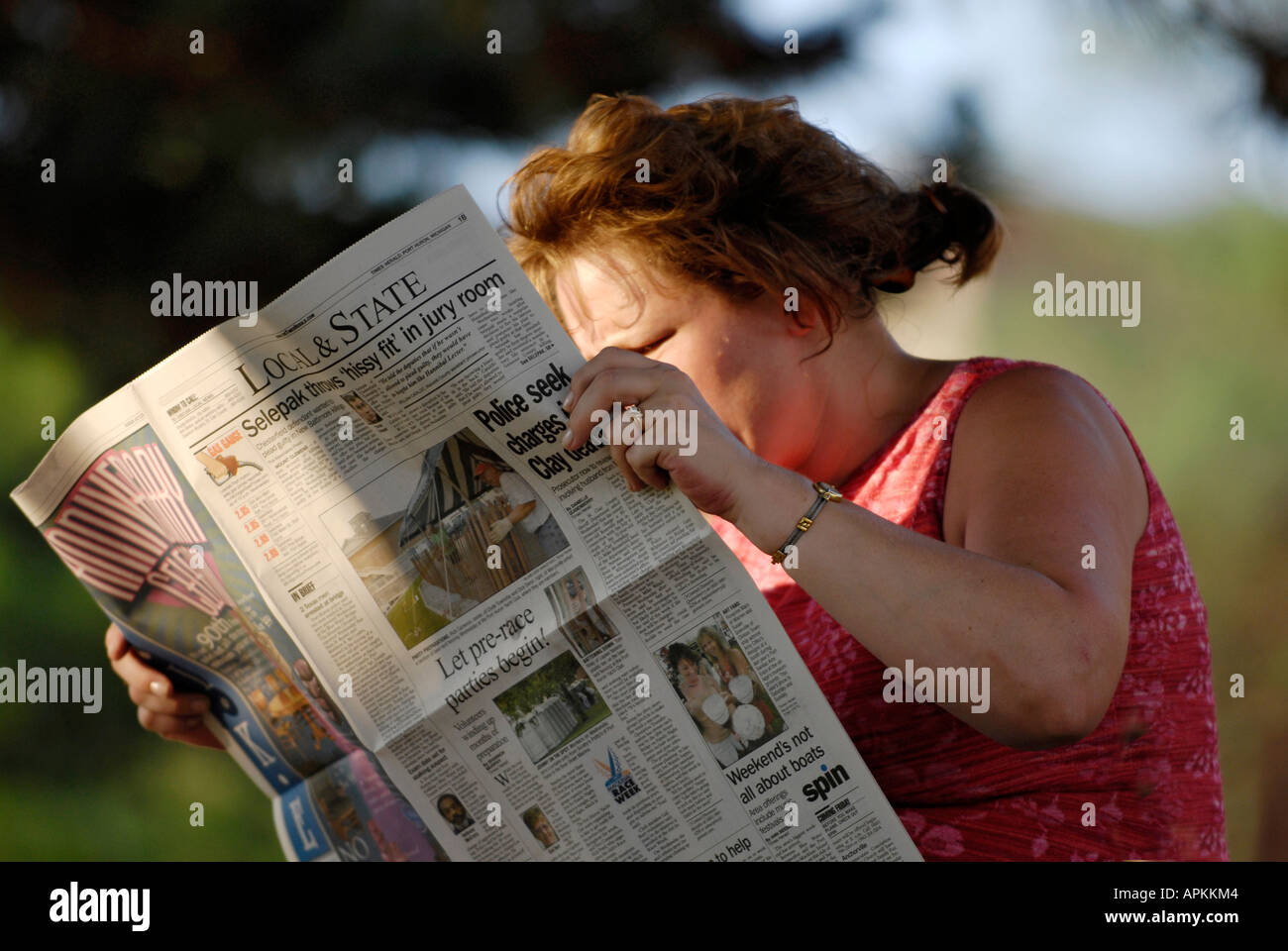 Female reading the newspaper outside Stock Photo