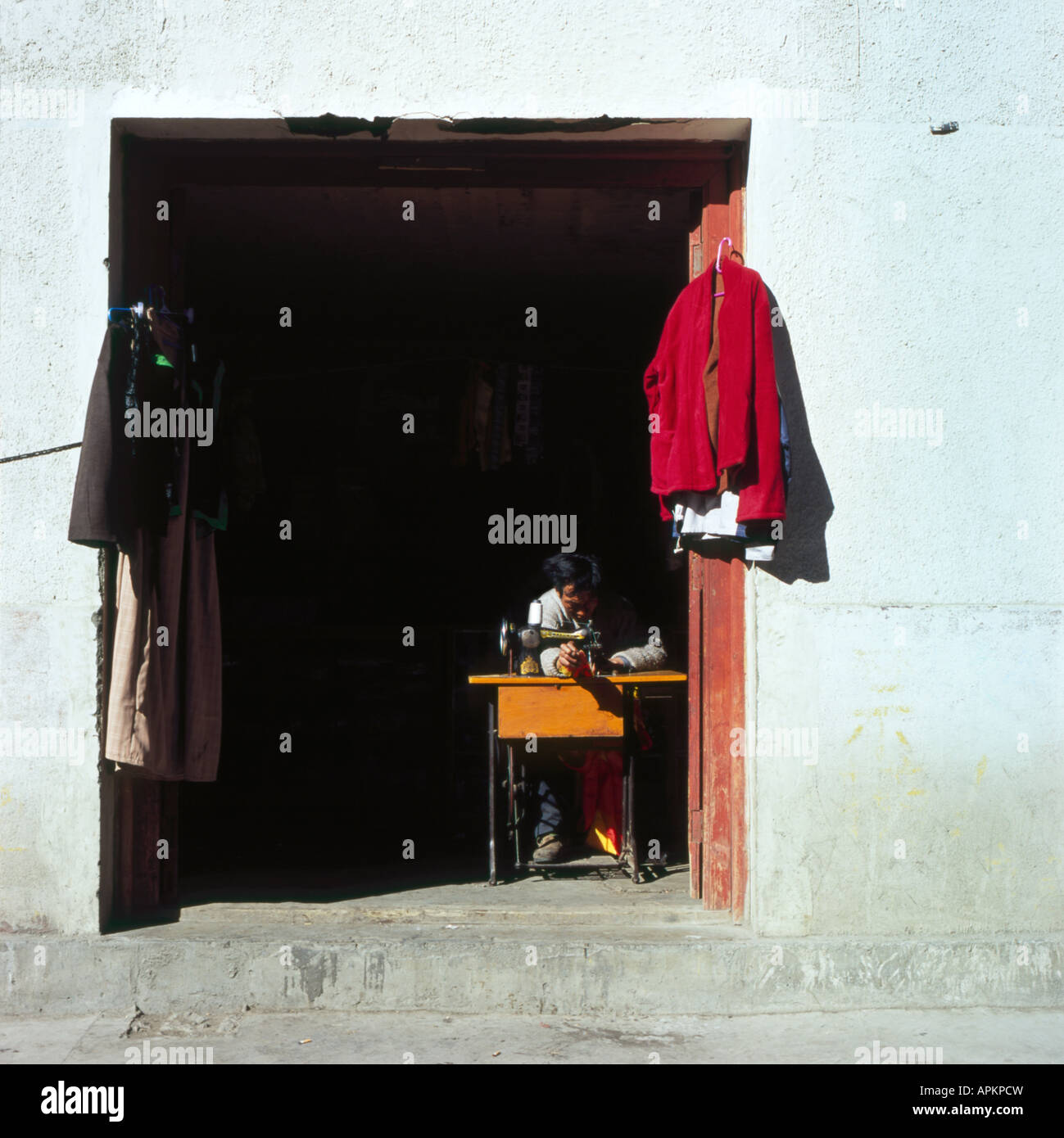 street dress maker in an entrance, China, Sichuan, Kangding Stock Photo