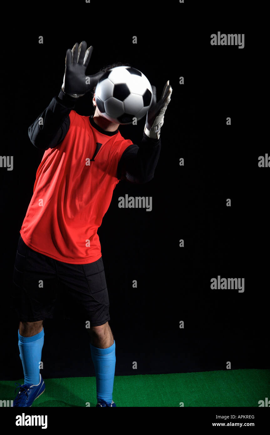 Goalkeeper chasing ball Stock Photo