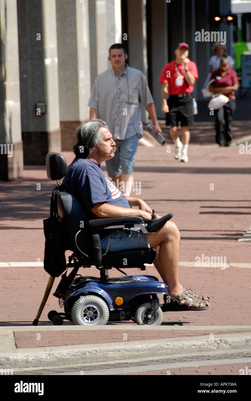 Handicapped male in a battery powered wheelchair in downtown