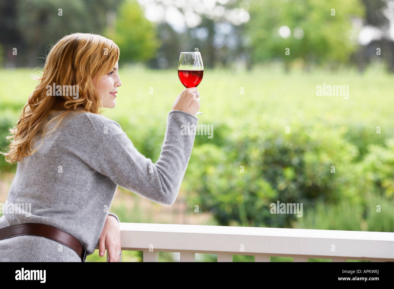 Young woman holding glass of red wine Stock Photo - Alamy