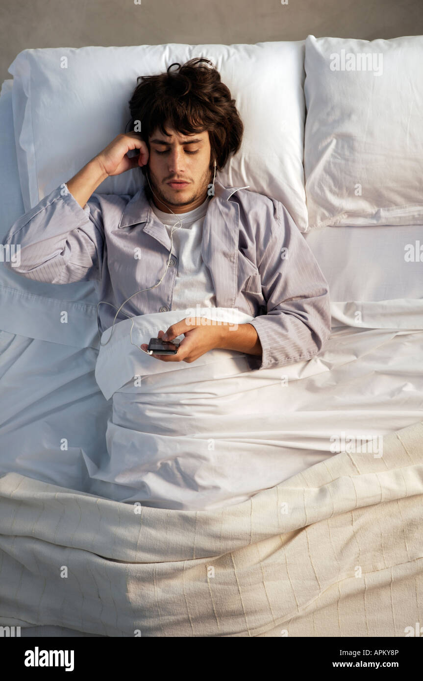 Man listening to music in bed Stock Photo - Alamy