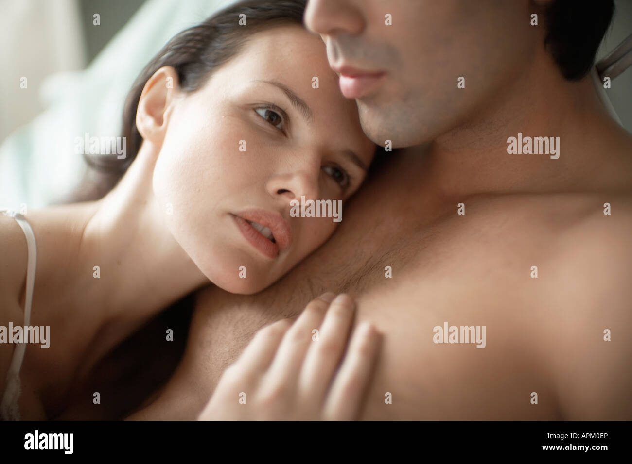 Woman resting head on man's chest Stock Photo