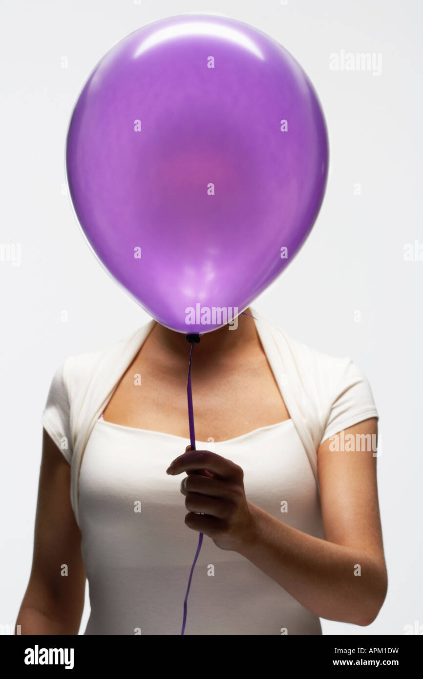 Woman holding balloon in front of her face Stock Photo - Alamy