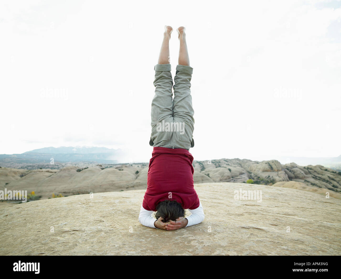 Man standing on head, rear view Stock Photo - Alamy