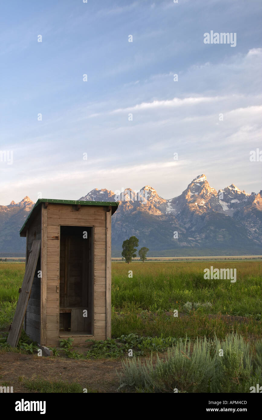 Old outhouse in meadow below the Grand Teton in early morning Grand Teton National Park Teton County Wyoming USA Stock Photo