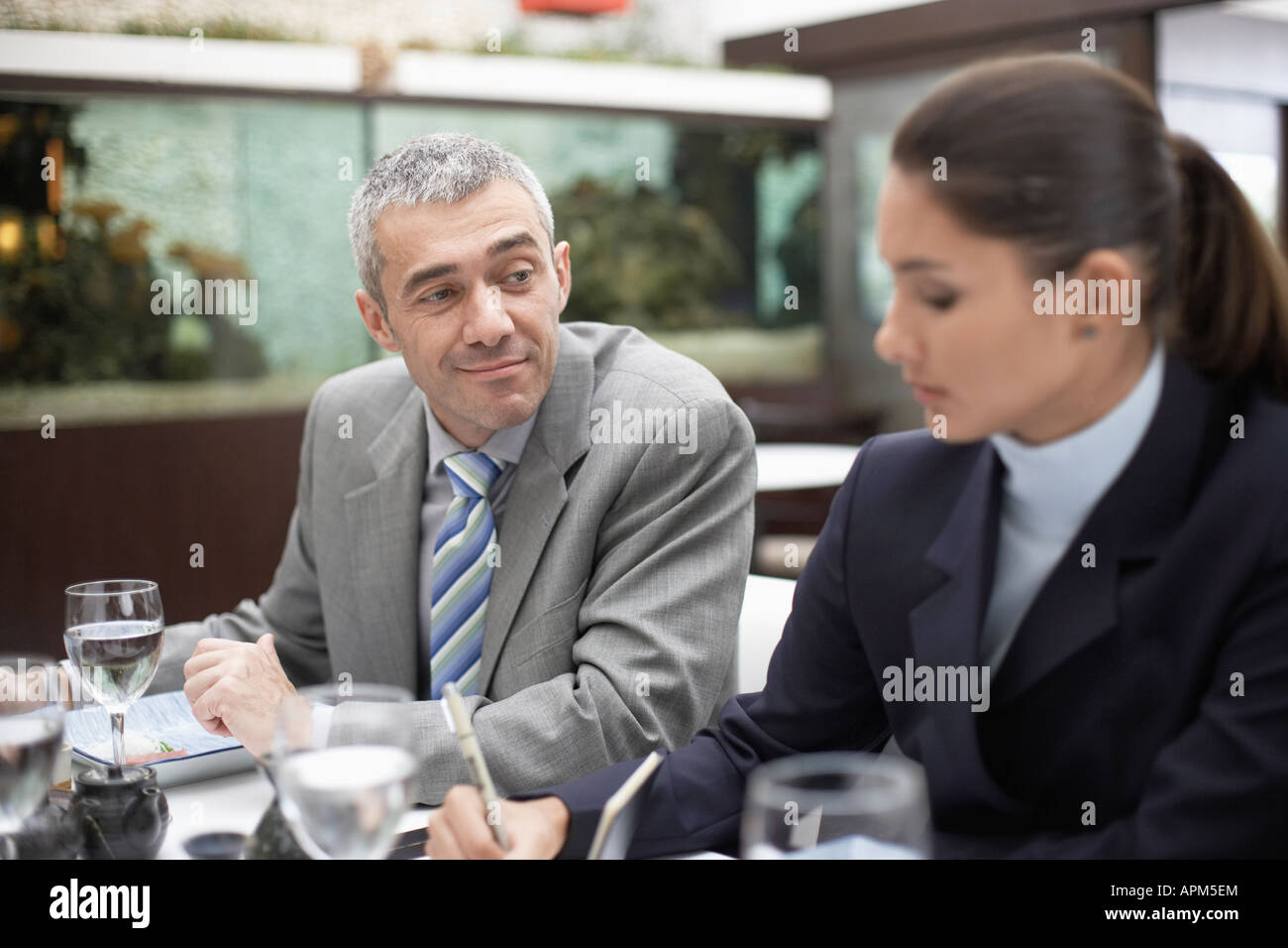 Businessman looking at woman making notes Stock Photo