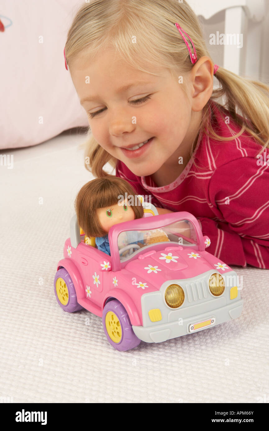 a girl plays on the floor with a toy car and doll Stock Photo - Alamy