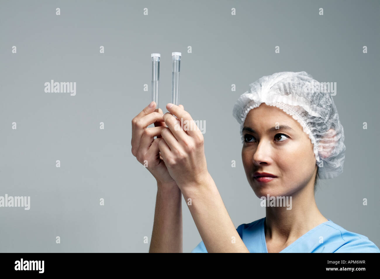 Lab female doctor looking at test tubes Stock Photo - Alamy