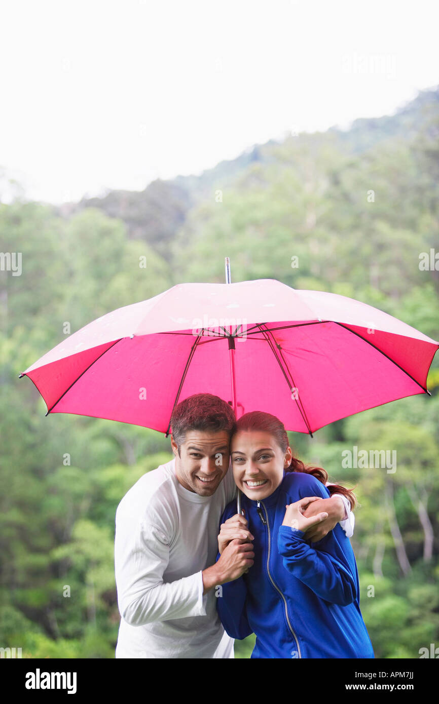 Couple hugging under umbrella Stock Photo - Alamy
