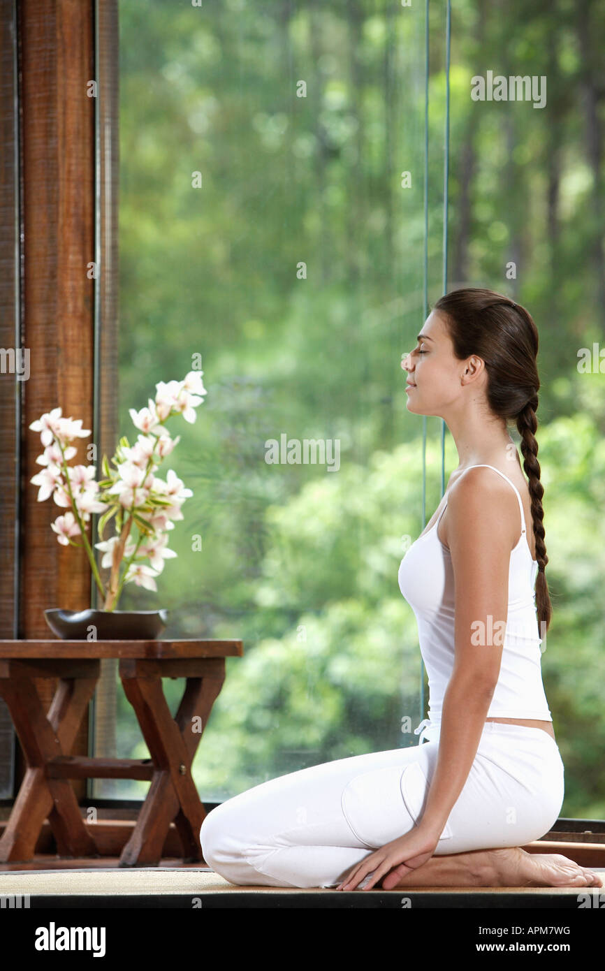 Woman meditating on floor near window Stock Photo - Alamy