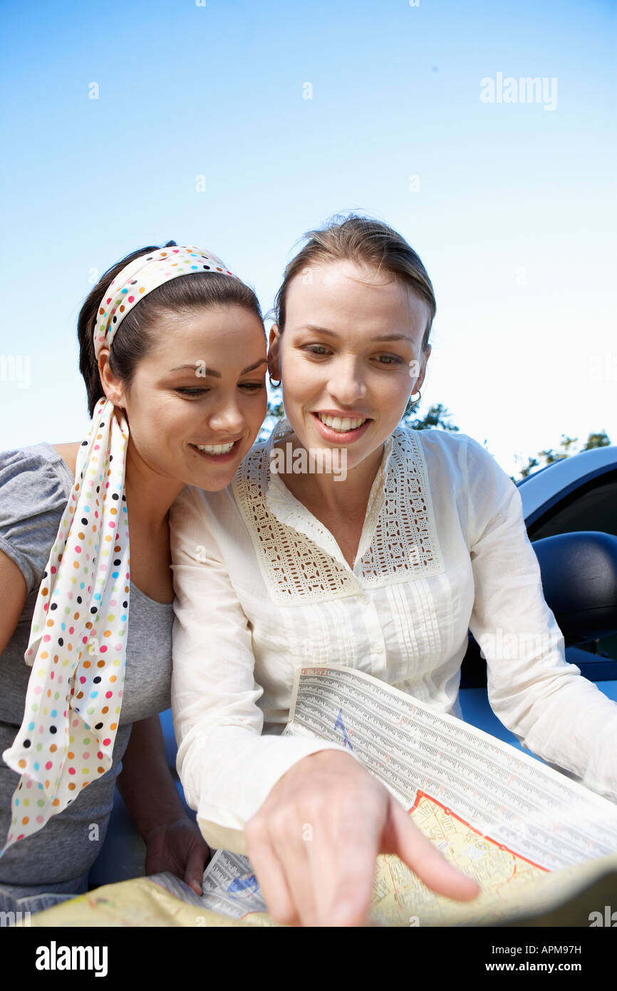Two women reading road map Stock Photo Alamy