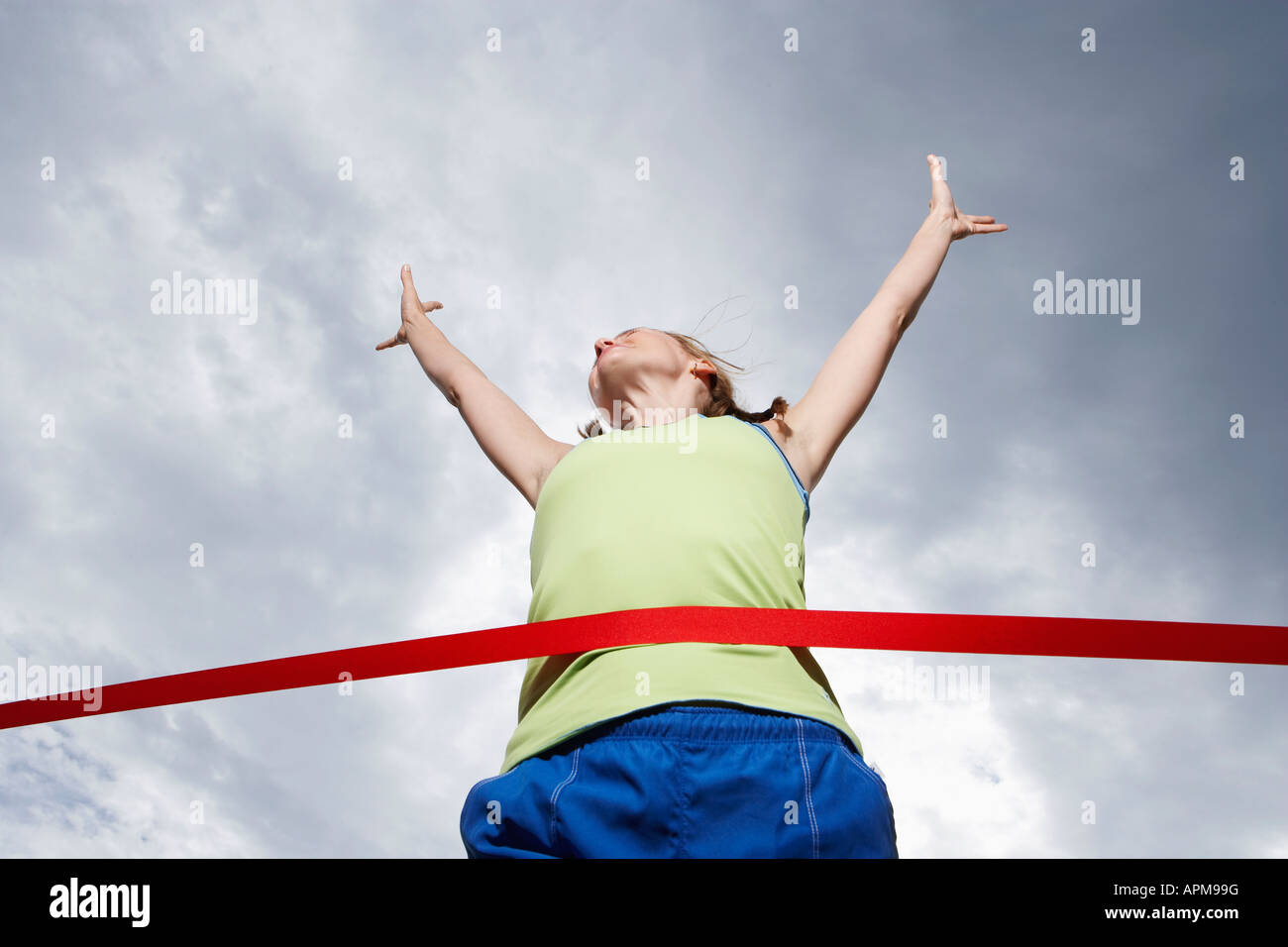 Female runner crossing finishing line (low angle view) Stock Photo