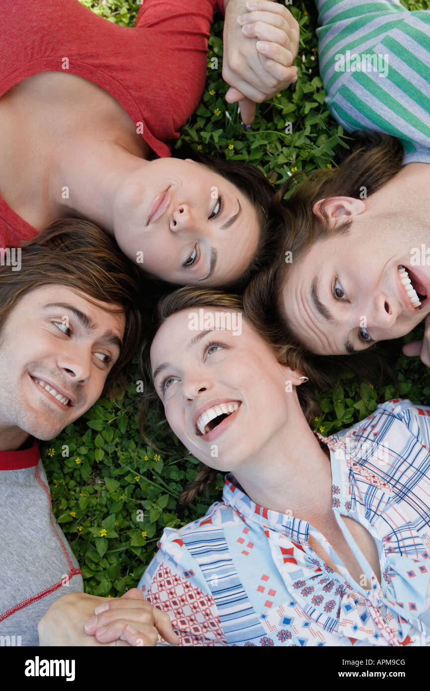 Four friends lying on grass hi-res stock photography and images - Alamy