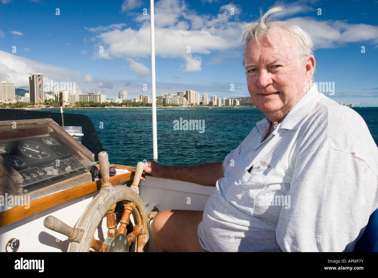 Captain on bridge at wheel of power boat Waikiki Beach Honolulu Hawaii