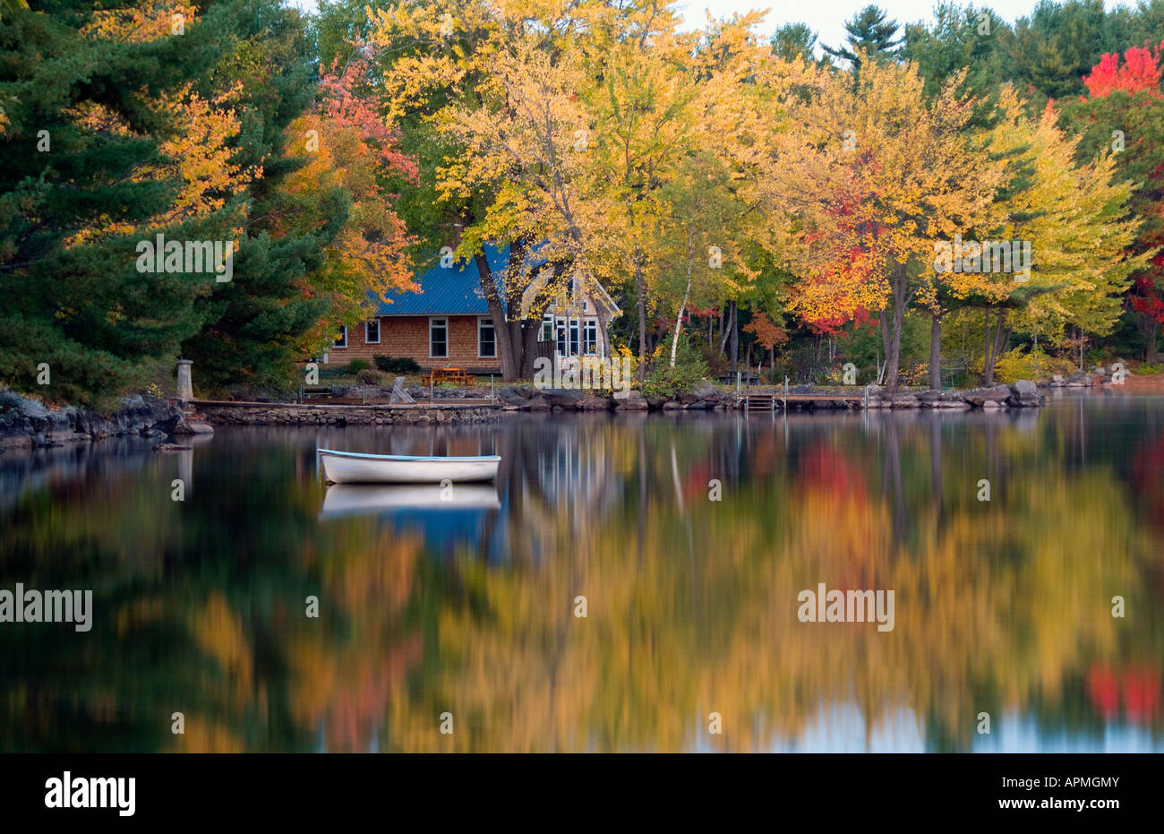 Peaceful quiet scene of lake and small boat in Long Lake in Bridgton Maine in New England colorful scene with reflections Stock Photo