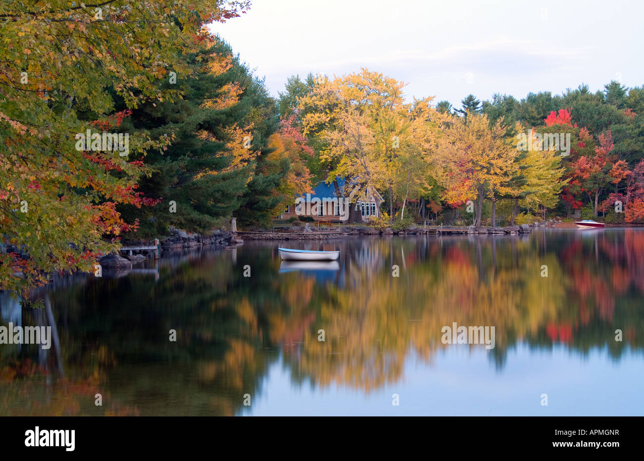 Peaceful quiet scene of lake and small boat in Long Lake in Bridgton Maine in New England colorful scene with reflections Stock Photo
