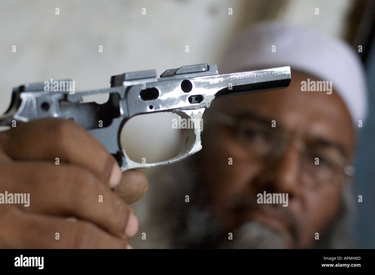 A traditional Pakistani gunmaker holding the frame of an original Beretta gun in Darra Adam Khel Pakistan Stock Photo