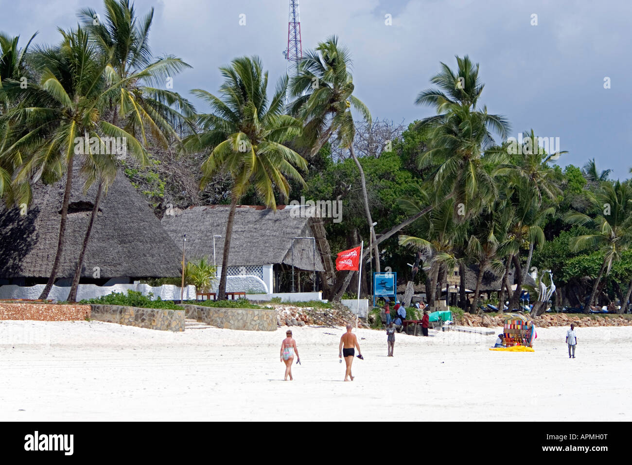 Tropical white sand beach and thatch African style buildings Diani