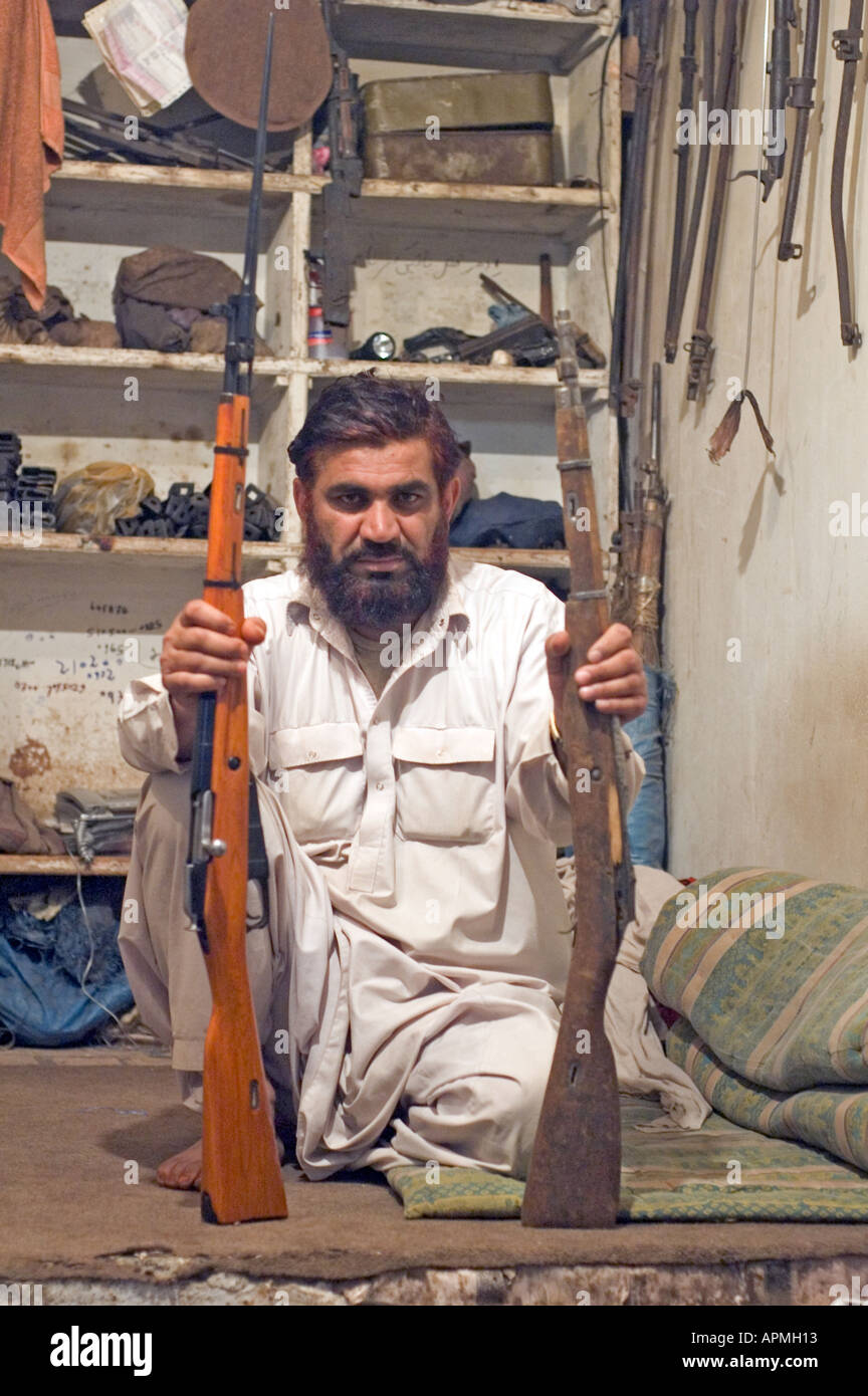 A man holding two WW2 Soviet rifles in Darra Pakistan His job consists of refurbishing those old guns Stock Photo