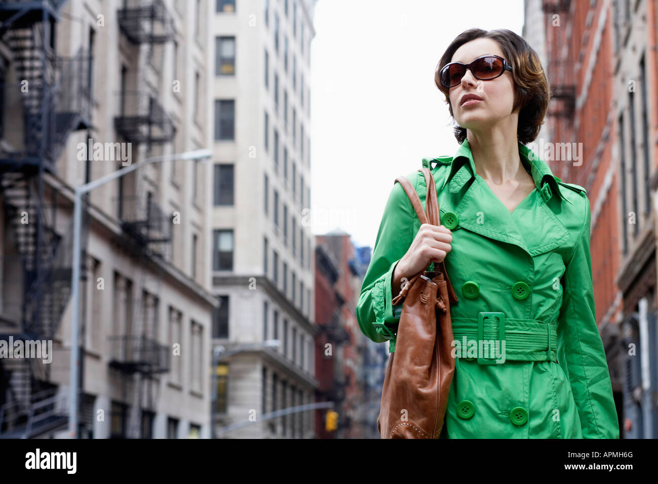 Mid adult woman in green coat walking on street, New York City, New ...