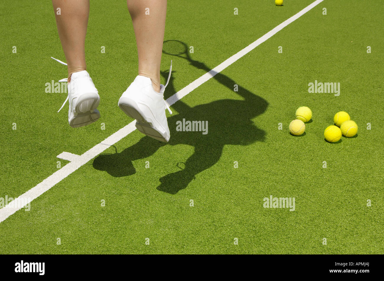 Tennis player jumping near tennis balls (focus on feet Stock Photo Alamy