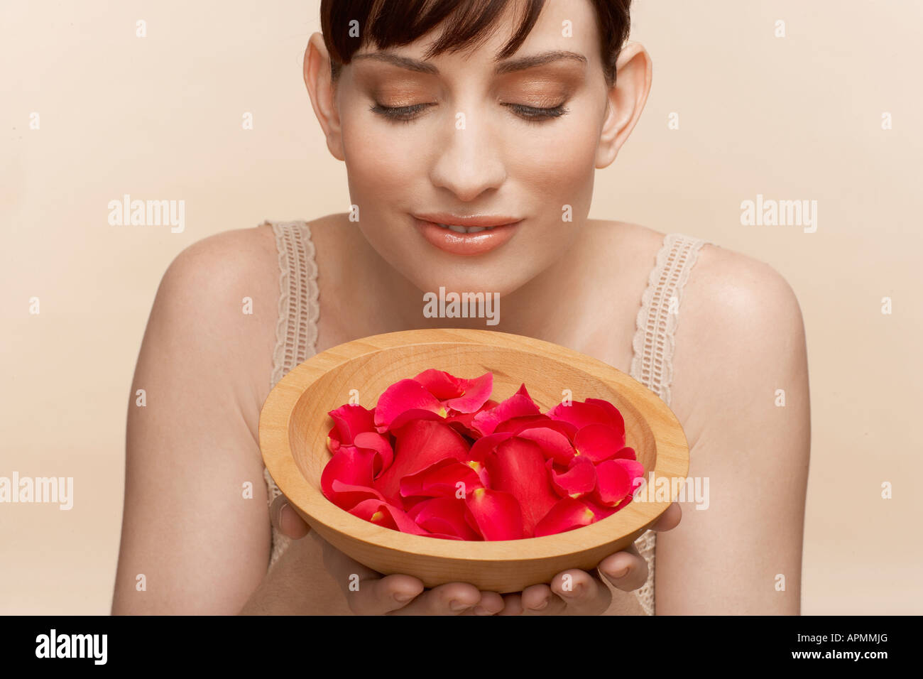 Mid adult woman holding bowl of petals Stock Photo