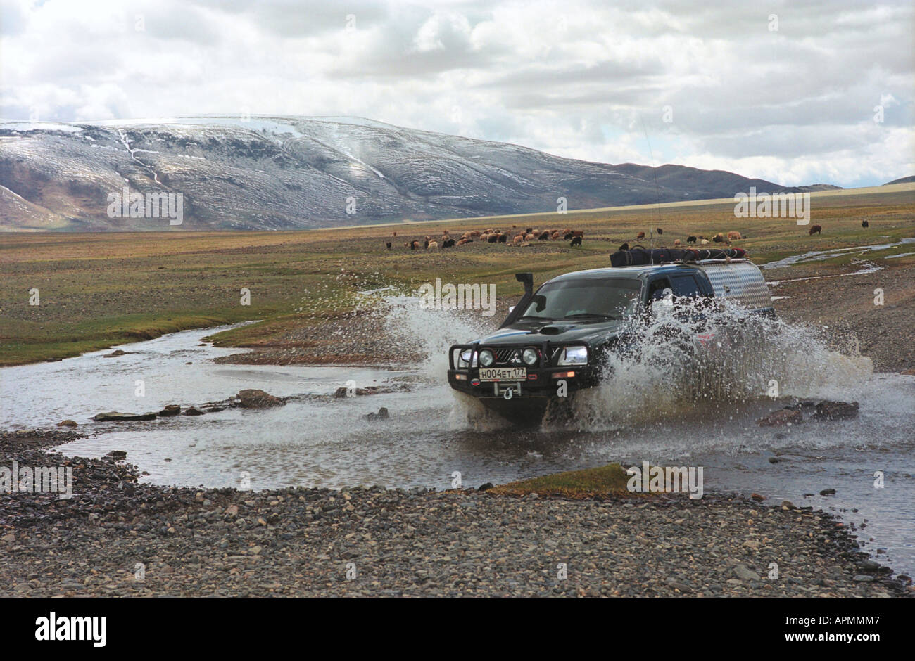 Off-road vehicle crosses a brook. The Buratyn Daba Pass. Khovd aimag (province). West Mongolia Stock Photo