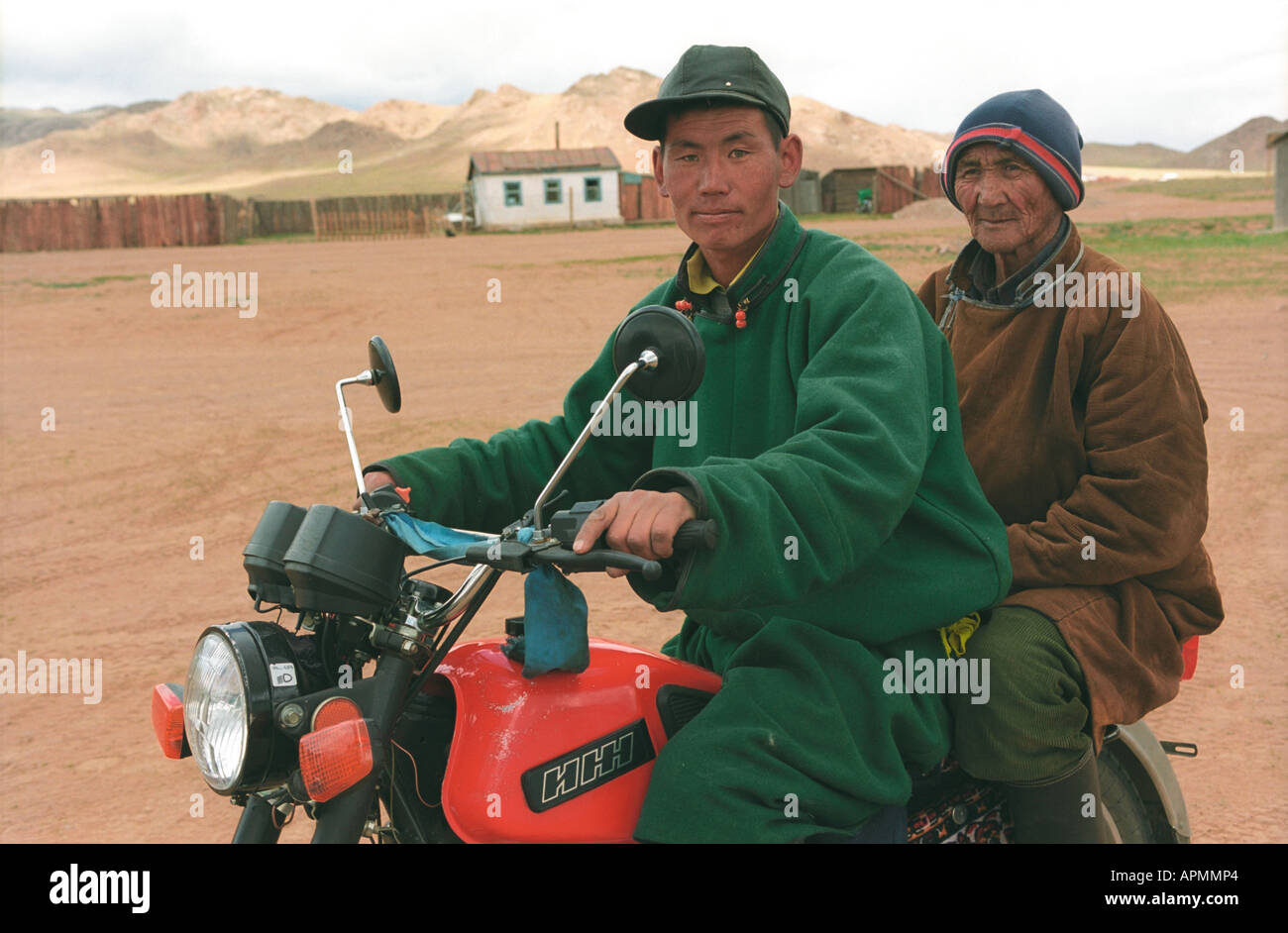 Men in national Mongolian clothes del on motorcycle. Numrug somon (village). Zavkhan aimag (province). Mongolia Stock Photo