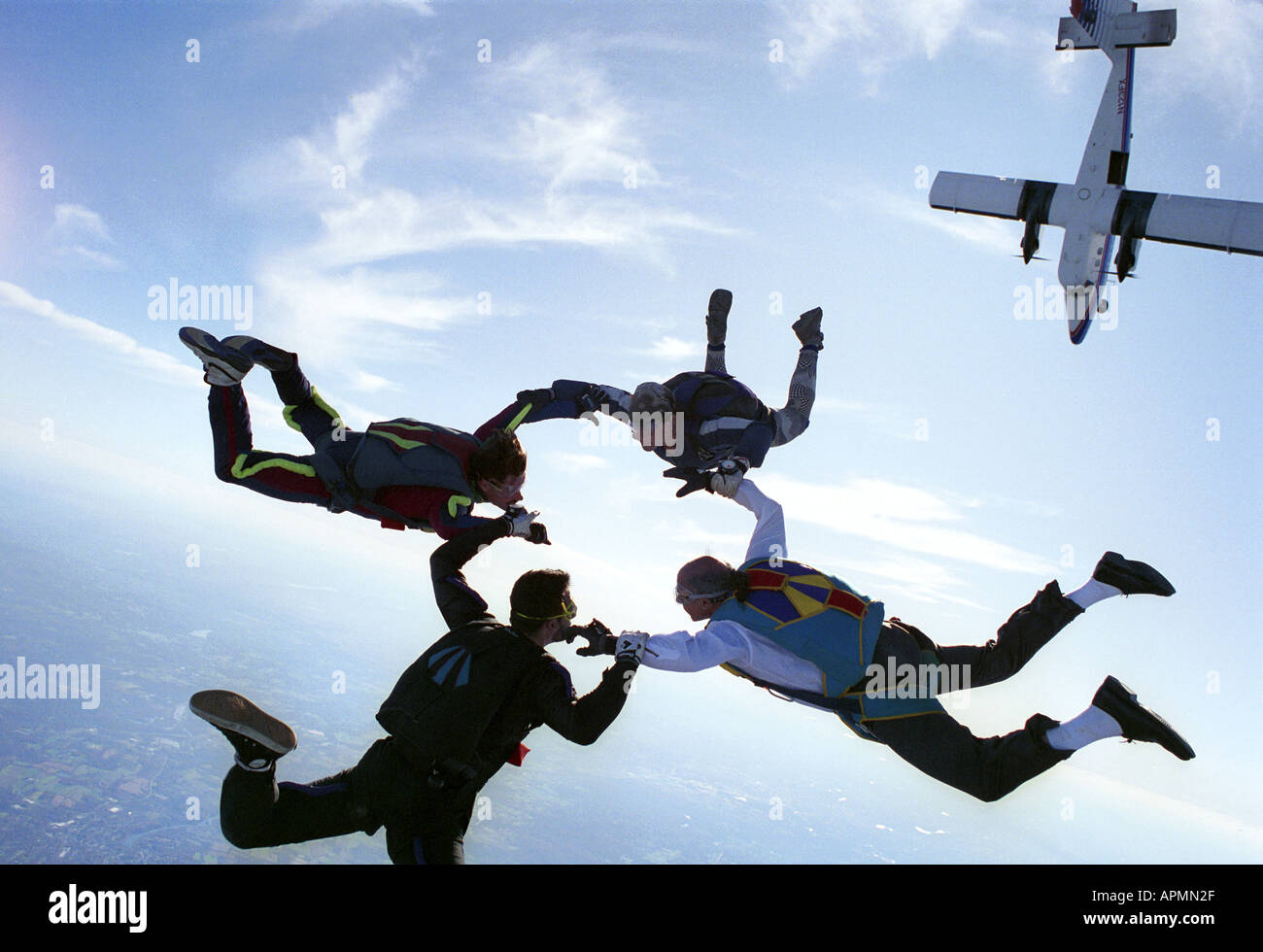 Four skydivers in freefall holding hands Stock Photo - Alamy