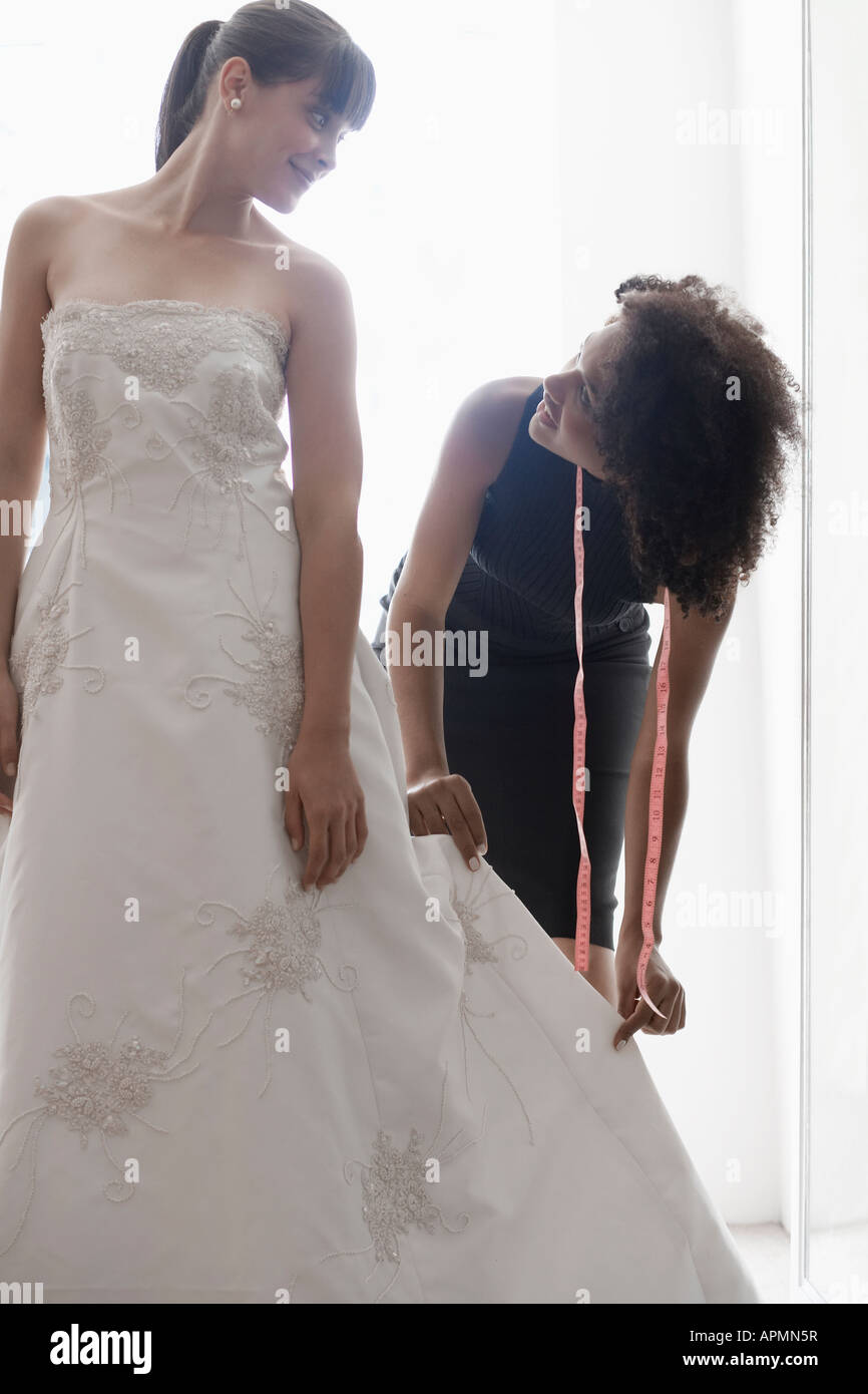 Woman adjusting bride's wedding dress Stock Photo