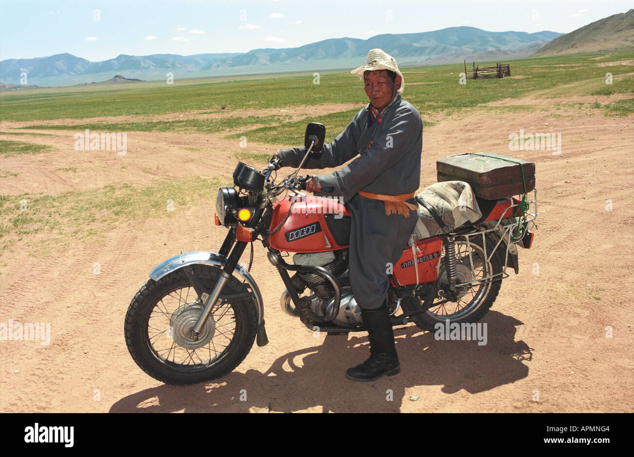 Men in national Mongolian clothes del on motorcycle. Burentogtoh village. Khovsgol aimag (province). North Mongolia Stock Photo