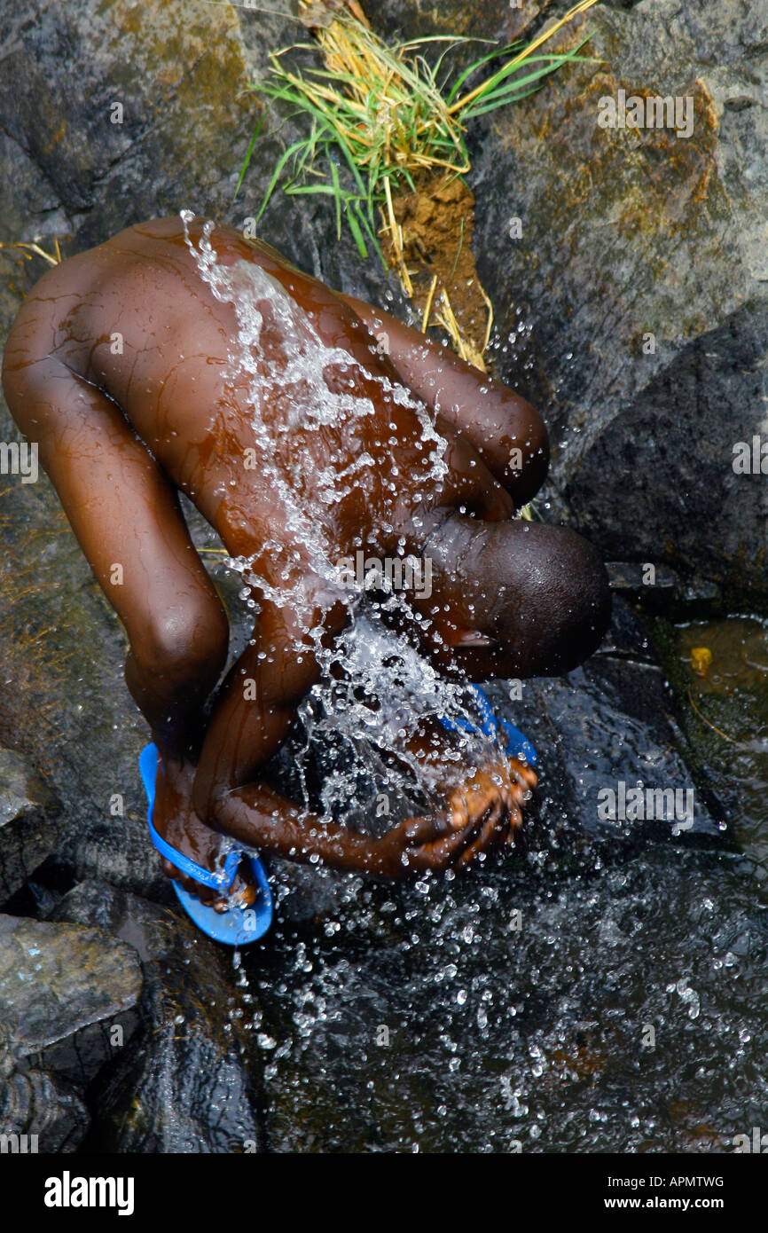 In a country where water is precious, a young man washes himself in a small stream in northern Uganda. Stock Photo